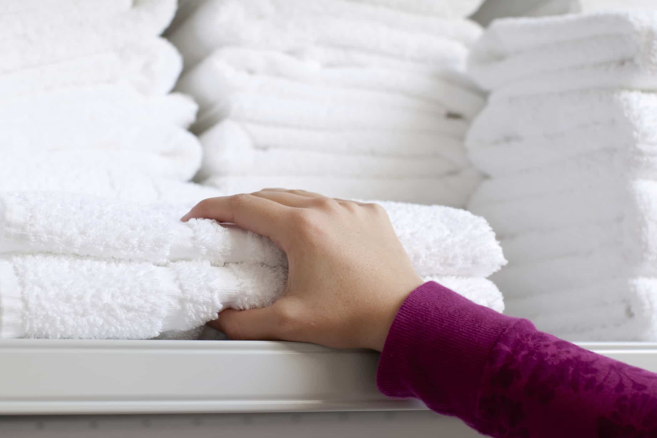 Person grabbing a stack of towels
