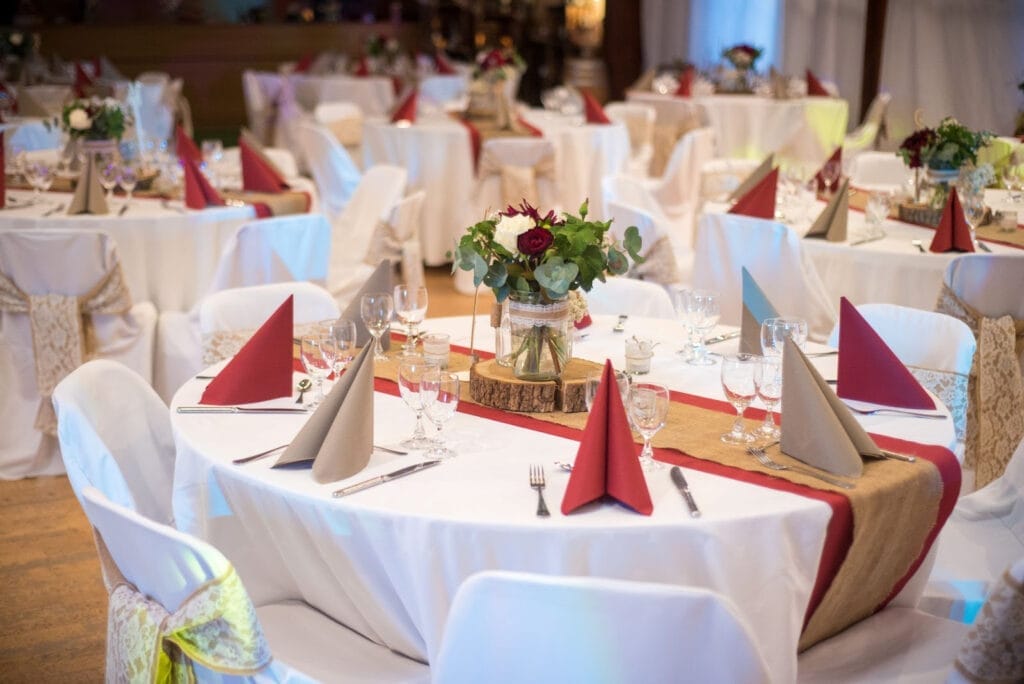 Grand ballroom event setup, banquet tables, linens, lighting for a large gala event.