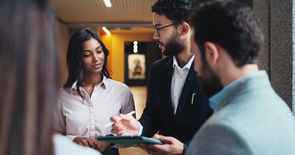 Business man holding a tablet and talking to a woman.