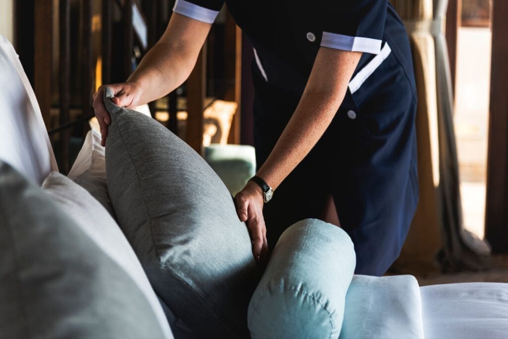 Hotel employee making a bed