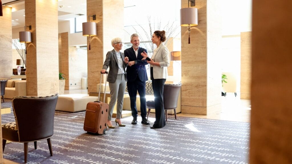 Hotel employee speaking with guests.